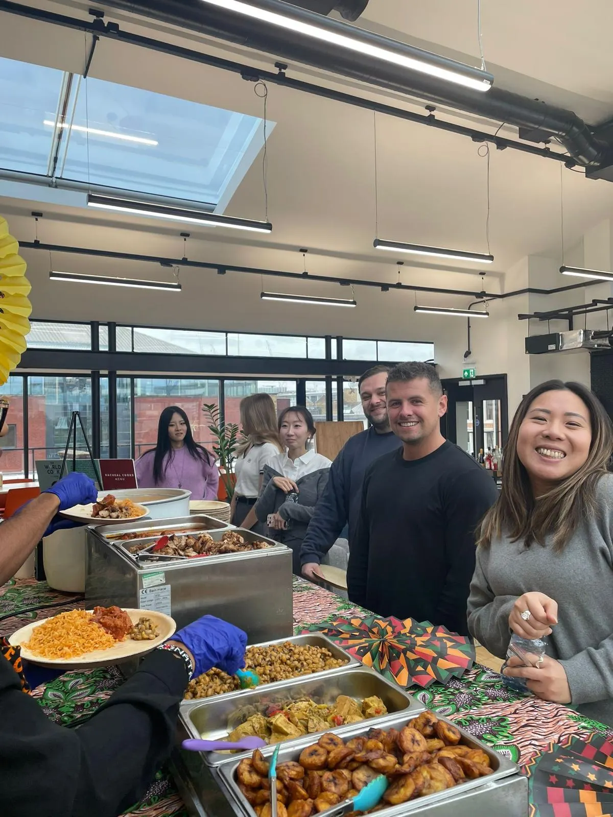 Office team at a Racheal Cooks buffet of jollof, beans and plantain