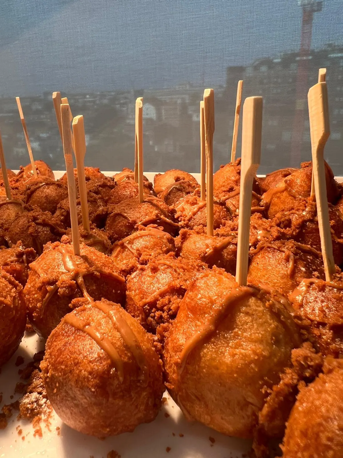 Glazed puff-puff on bamboo picks